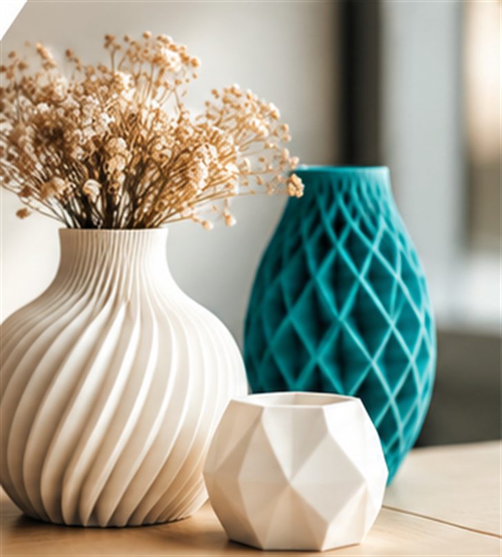 Weisse Vase mit Spiralrillen und Trockenblumen, daneben eine türkise Gittervase und ein kleines weisses Facettengefäss auf einem Holztisch